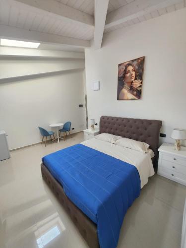 une chambre avec un grand lit avec une couverture bleue dans l'établissement Villa Patty, à Sala Bolognese