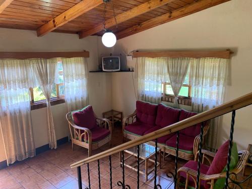a living room with purple chairs and a staircase at Hotel Posada Kamol Bey in Panajachel