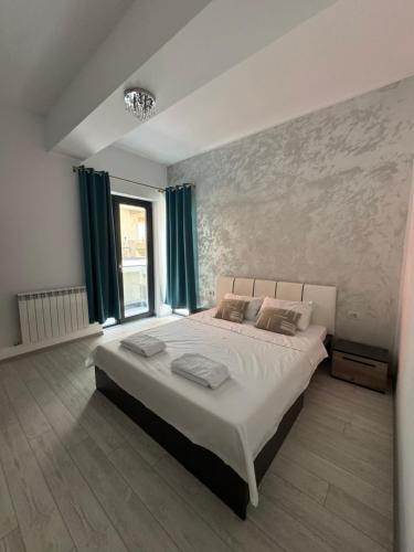 ein Schlafzimmer mit einem großen Bett mit grünen Vorhängen in der Unterkunft Blue Apartment in Năvodari