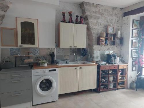 une cuisine avec un évier et une machine à laver dans l'établissement Appartement confortable à Roujan de 50 m², à Roujan
