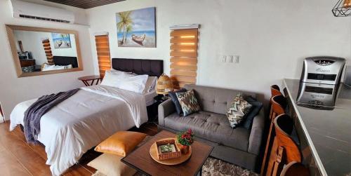 a bedroom with a bed and a couch at Barney's Pointe Beach House, Batangas City in Batangas City