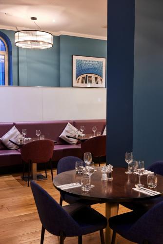 a dining room with tables and chairs with wine glasses at Thistle London Holborn in London