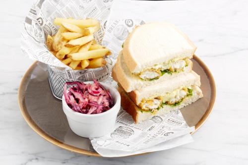 a plate with a sandwich and fries and a bowl of coleslaw at Holiday Inn Lancaster by IHG in Lancaster