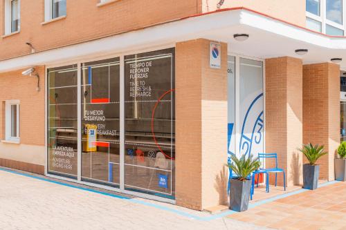 a store front with glass windows and a blue chair at Ibis Budget Madrid Calle Alcalá in Madrid