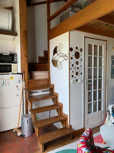 - un escalier en bois dans une cuisine à côté d'un réfrigérateur dans l'établissement Magnifique appartement métro Voltaire, à Paris