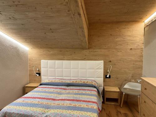 a small bedroom with a bed and a sink at Sappada Family Apartments in Sappada