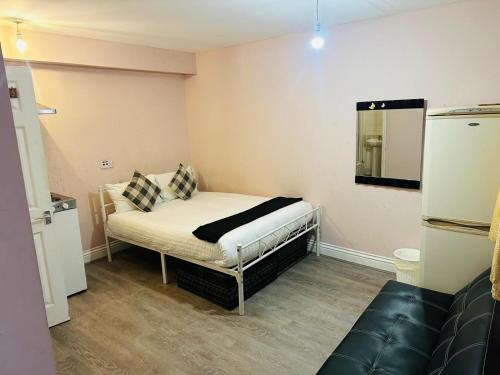 a small room with a bed and a mirror at Sterling Bed & Breakfast in Ilford