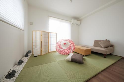 a living room with a couch and a pink umbrella at Felice Haneda in Tokyo
