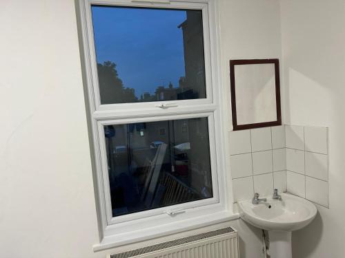 a bathroom with a window and a sink at Sterling Bed & Breakfast in Ilford