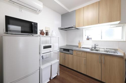 a kitchen with a refrigerator and a sink at Felice Haneda in Tokyo