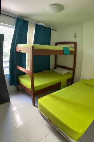 a room with two bunk beds and a window at Playa Los Cocos Apat 2 y 3 in Santa Marta