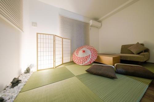 a living room with a couch and a pink umbrella at Felice Haneda in Tokyo