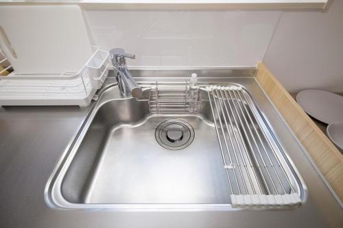 a kitchen sink with a dish drying rack next to it at Felice Haneda in Tokyo