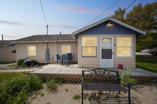ein kleines Haus mit einer Bank davor in der Unterkunft One bedroom cottage on the beach in Oscoda
