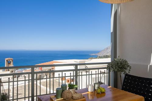 a balcony with a table and a view of the ocean at Thèas House in Mírthios