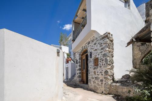 a narrow alley with white buildings and a door at Thèas House in Mírthios