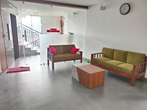 a living room with two couches and a coffee table at Maryland Residency in Meenangadi