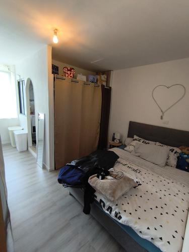 une chambre avec un lit avec un cœur sur le mur dans l'établissement Petite maison en bord de Marne, à Saint-Dizier