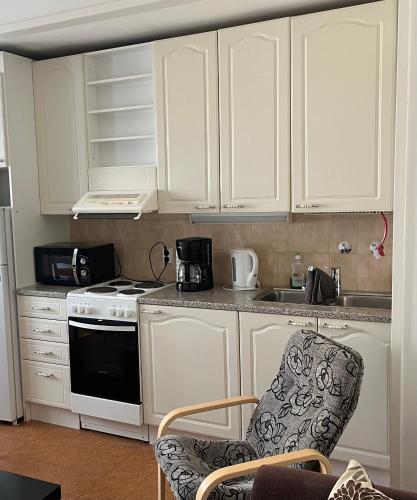 a kitchen with white cabinets and a stove top oven at Yksiö Kiertokatu in Pori