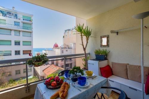 une table avec un bol de fruits sur un balcon dans l'établissement LES CARAIBES AP4473 by Riviera Holiday Homes, à Nice