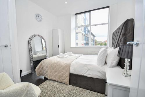 a bedroom with a bed with a mirror and a chair at Cosy & Bright 1 Bedroom Apartment in Bradford in Bradford