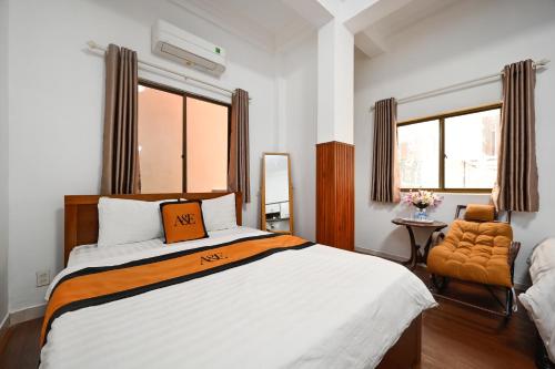 a bedroom with a bed and a chair and a window at A&E Guesthouse in Ho Chi Minh City