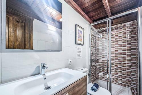 a white bathroom with a sink and a toilet at Casa Sussa in Tías