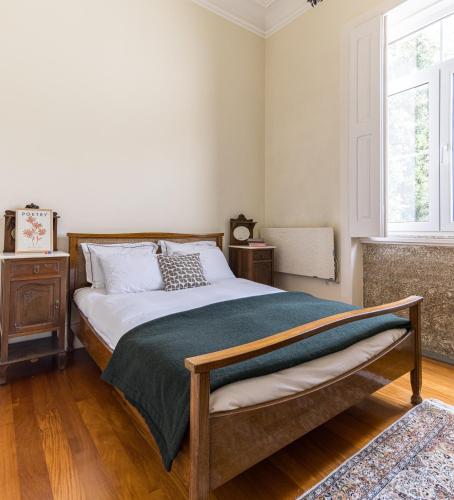 a bedroom with a bed with a green blanket at Vila Mar Beach House in Arcozelo