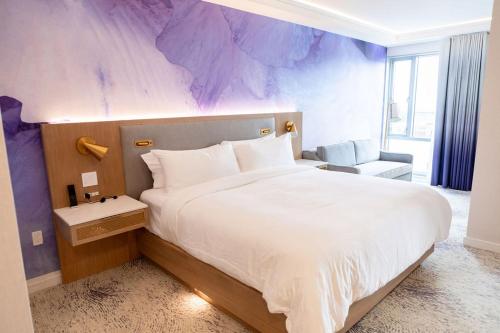 a bedroom with a large bed with a purple wall at Iris Hotel Boston in Brookline