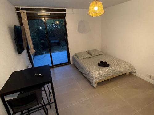 une chambre avec un lit, une table et une fenêtre dans l'établissement Nice studio in Montpellier, à Montpellier
