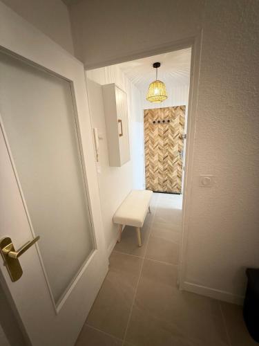 un couloir avec un banc blanc et une porte dans l'établissement Nice studio in Montpellier, à Montpellier