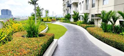 a walkway in front of a building with plants at AVIDA 1 2BR cloverleaf in Manila