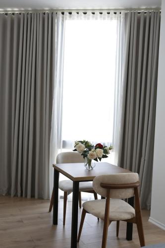 a dining room table and chairs in front of a window at Hotel La Rosa in Tirane