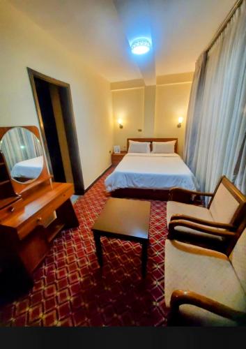 a hotel room with a bed and a desk at Keba Guest INN in Addis Ababa