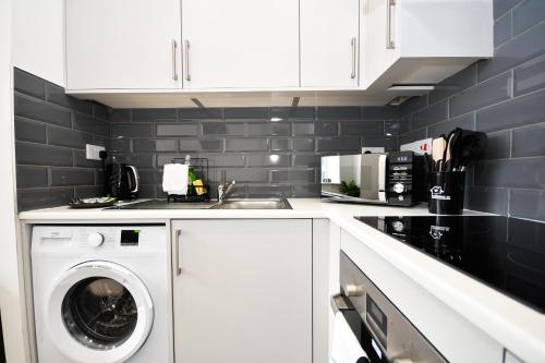 a white kitchen with a washing machine in it at Cosy & Bright 1 Bedroom Apartment in Bradford in Bradford