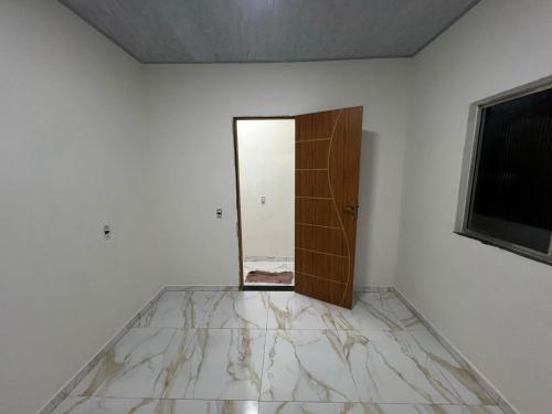 an empty room with a door and a mirror at Acomodação COP30 in Ananindeua