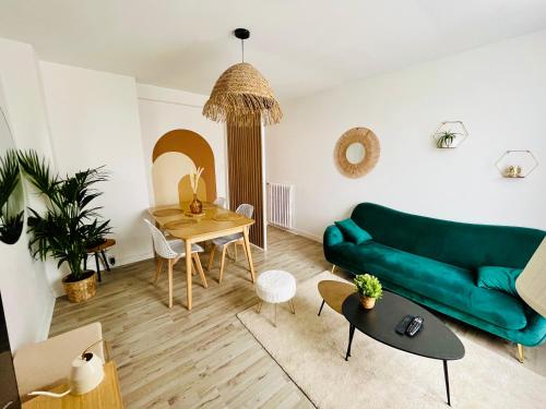 un salon avec un canapé vert et une table dans l'établissement Le cocon du peintre - Brest centre, à Brest