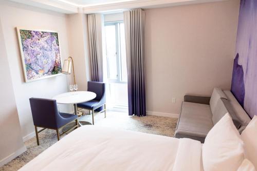a hotel room with a bed and a table and a couch at Iris Hotel Boston in Brookline