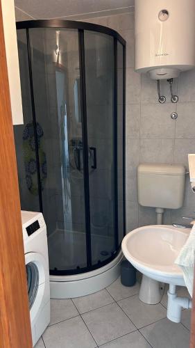 a bathroom with a shower and a washing machine at Old Town Primošten in Primošten