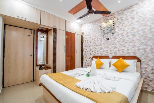 a bedroom with a large white bed with yellow pillows at Gagal Home - Powai Suite in Mumbai