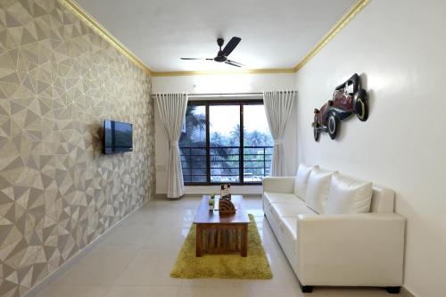 a living room with a white couch and a table at Gagal Home - Powai Suite in Mumbai