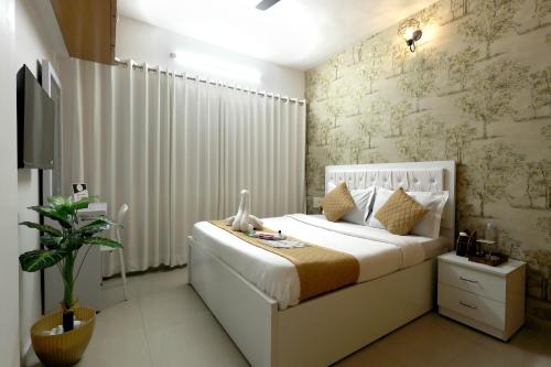 a bedroom with a large white bed and a plant at Gagal Home - Powai Suite in Mumbai