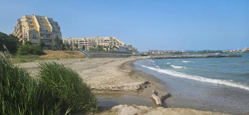 a sandy beach with a building in the background at Boho Breeze Aheloy in Aheloy