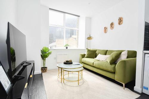 a living room with a green couch and a table at Cosy & Bright 1 Bedroom Apartment in Bradford in Bradford