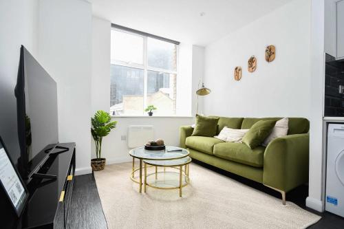 a living room with a green couch and a table at Cosy & Bright 1 Bedroom Apartment in Bradford in Bradford