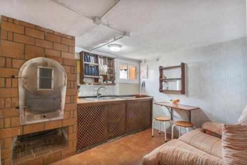 cocina y sala de estar con pared de ladrillo en Casa Haroldo, en Candelaria