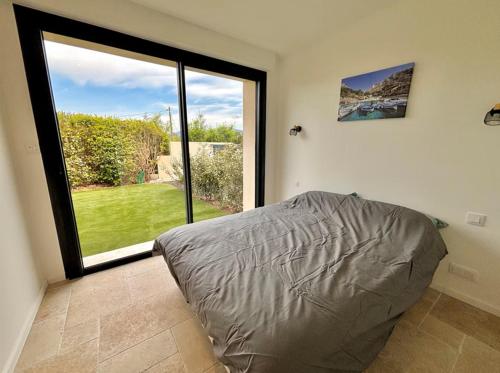 une chambre avec un lit et une grande fenêtre dans l'établissement villa capricorne, à Sainte-Maxime