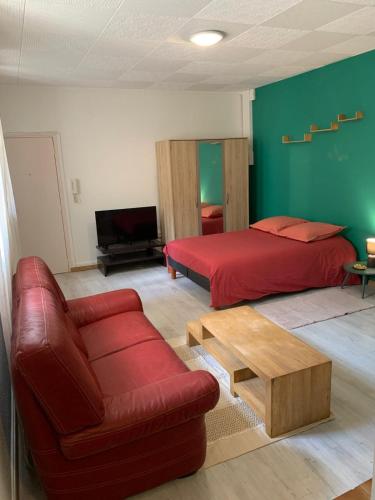- une chambre avec un lit rouge et un canapé rouge dans l'établissement Studio Carcassonne Hyper Centre, à Carcassonne