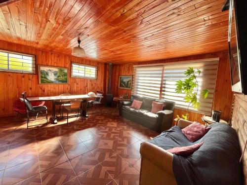 a living room with a couch and a table at Cabaña Camino Termas de Chillan Hermoso Recinto in El Cerrillo