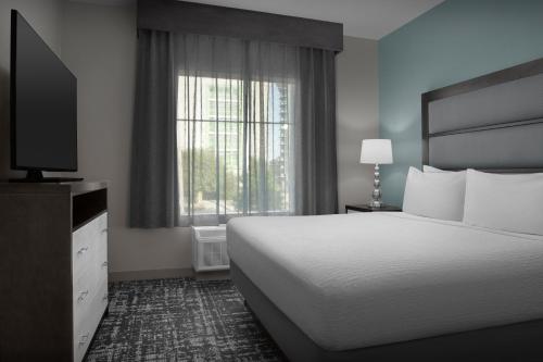 a hotel room with a bed and a television at Homewood Suites by Hilton Metairie New Orleans in Metairie
